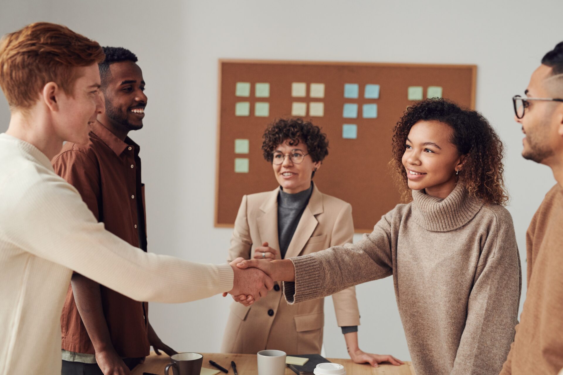 Diverse business people shaking hands in office.