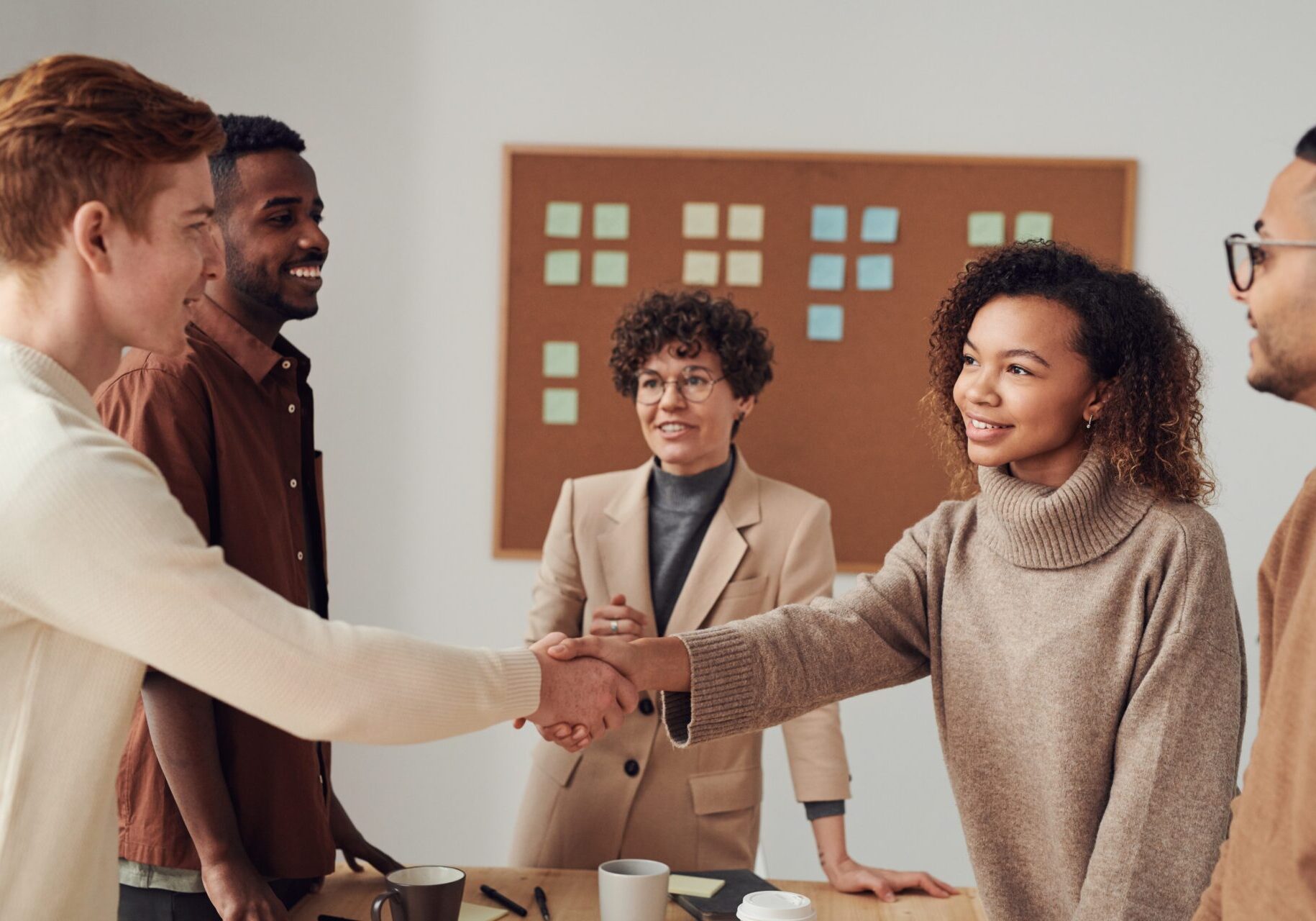 Diverse business people shaking hands in office.